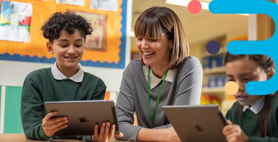 a teacher and students looking at a tablet in the classroom