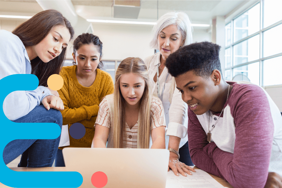 students and a teacher looking at a laptop