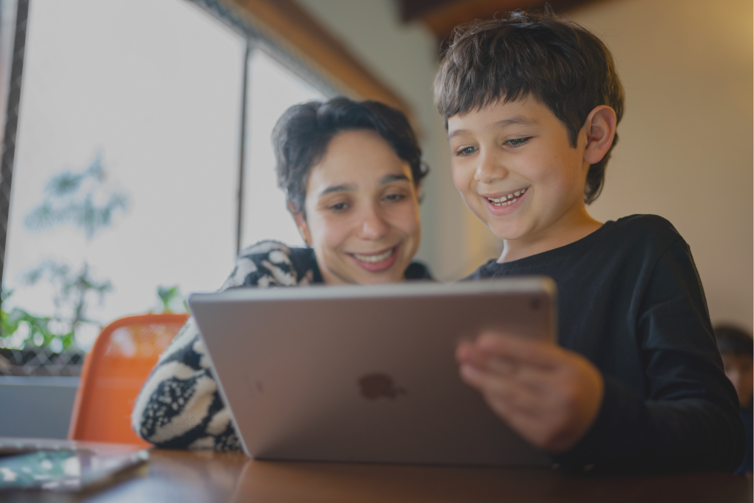 3 a mother and son looking at an iPad