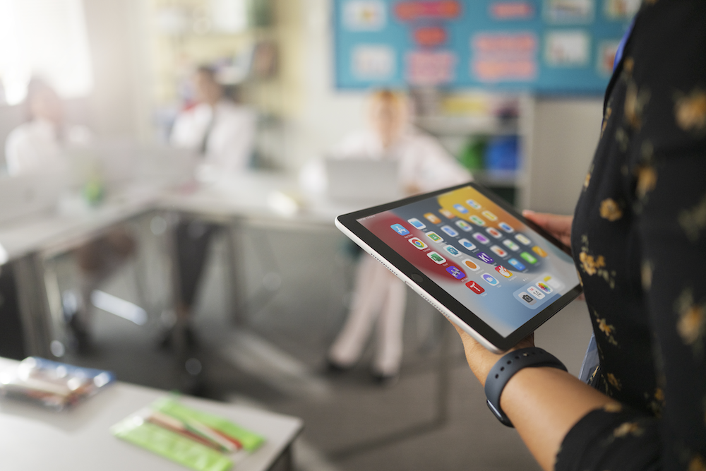 A teacher looking at her iPad in the classroom
