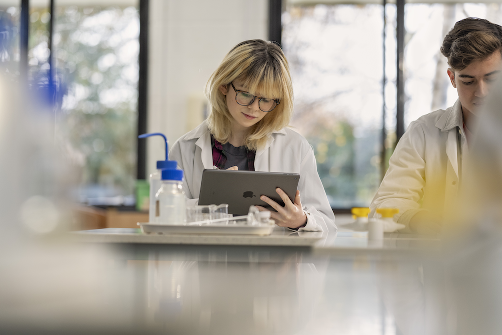 2 students in a science lab in school using ipads