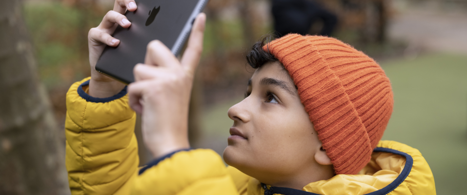 a boy using his ipad outside
