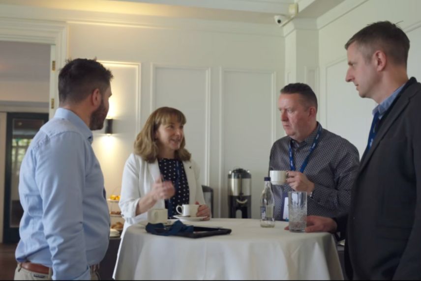 people talking while standing around a table people talking while standing around a table